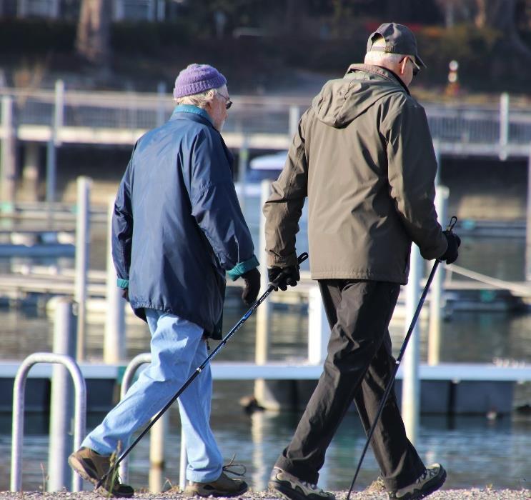 kaksi ikäihmistä kävelee ulkona