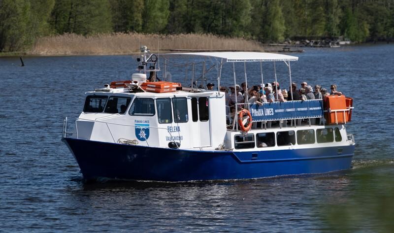 Pirkka Linesin M/S Helena lipuu järvellä, aluksen kannella on matkustajia.